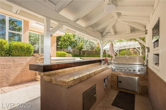 A covered outdoor bar with a built-in grill.
