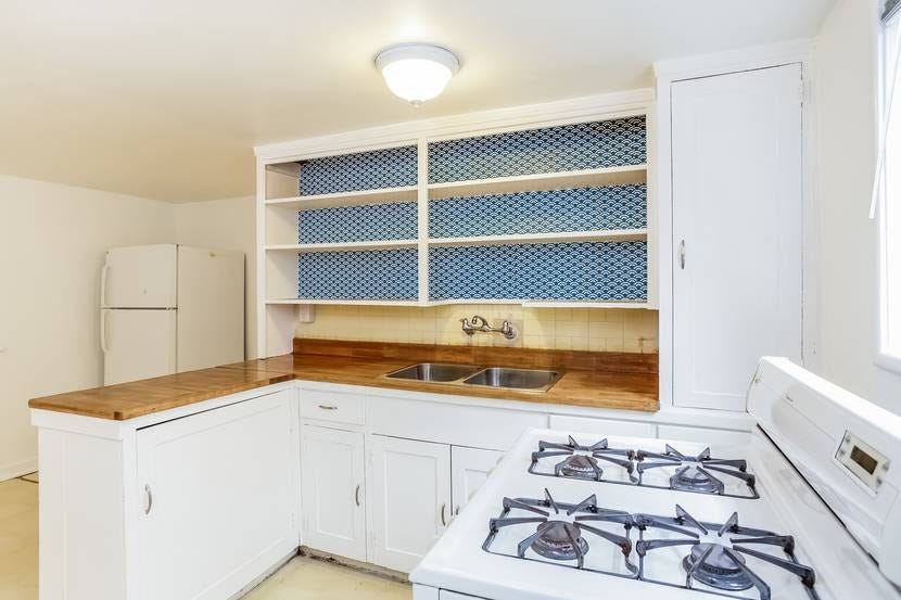 A kitchen with a peninsula blocking easy movement between the sink/stove area and the fridge in the far corner of the kitchen