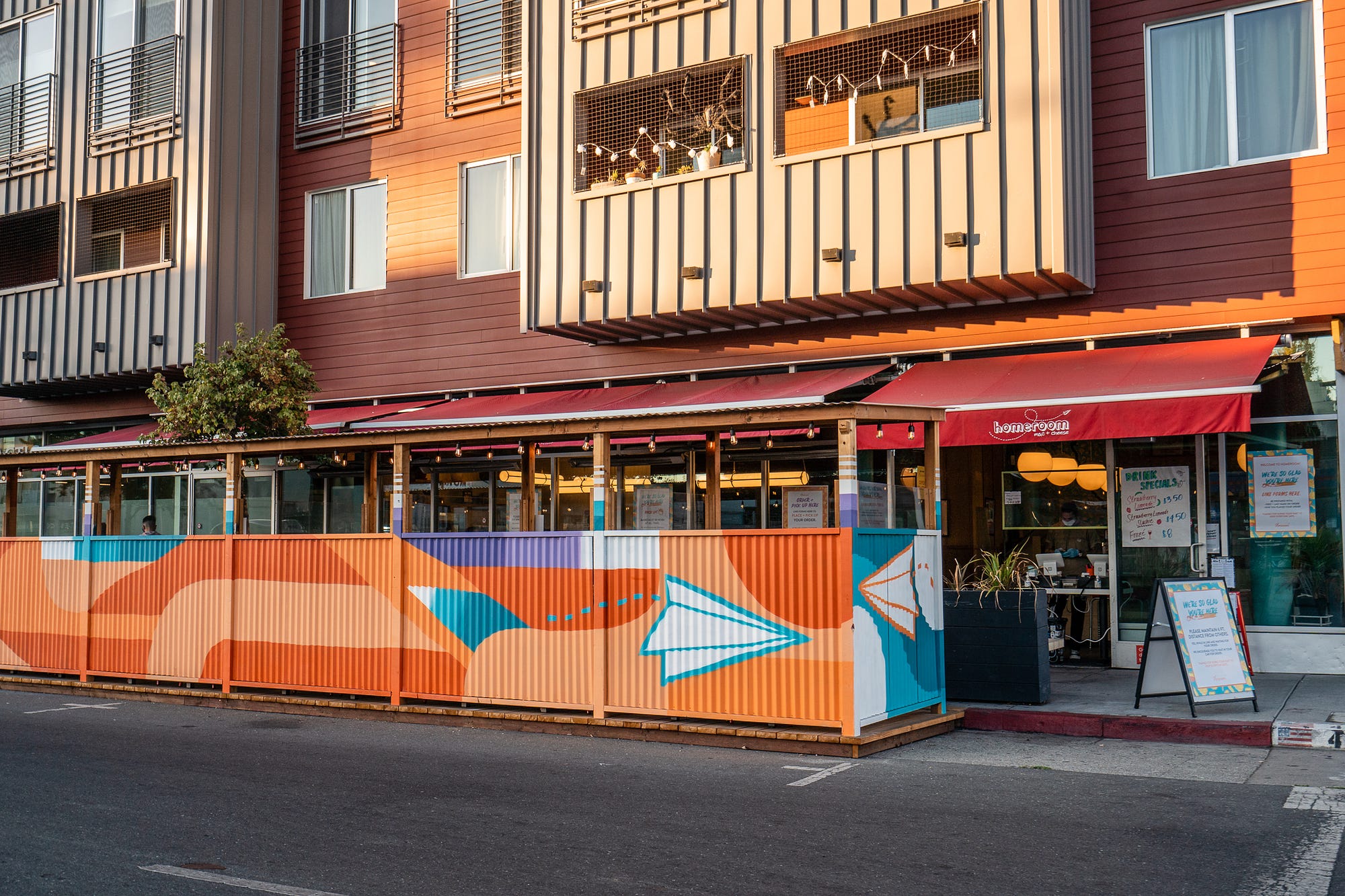 Homeroom‘s outdoor dining area, fenced off from the street by a fence painted with paper airplanes.