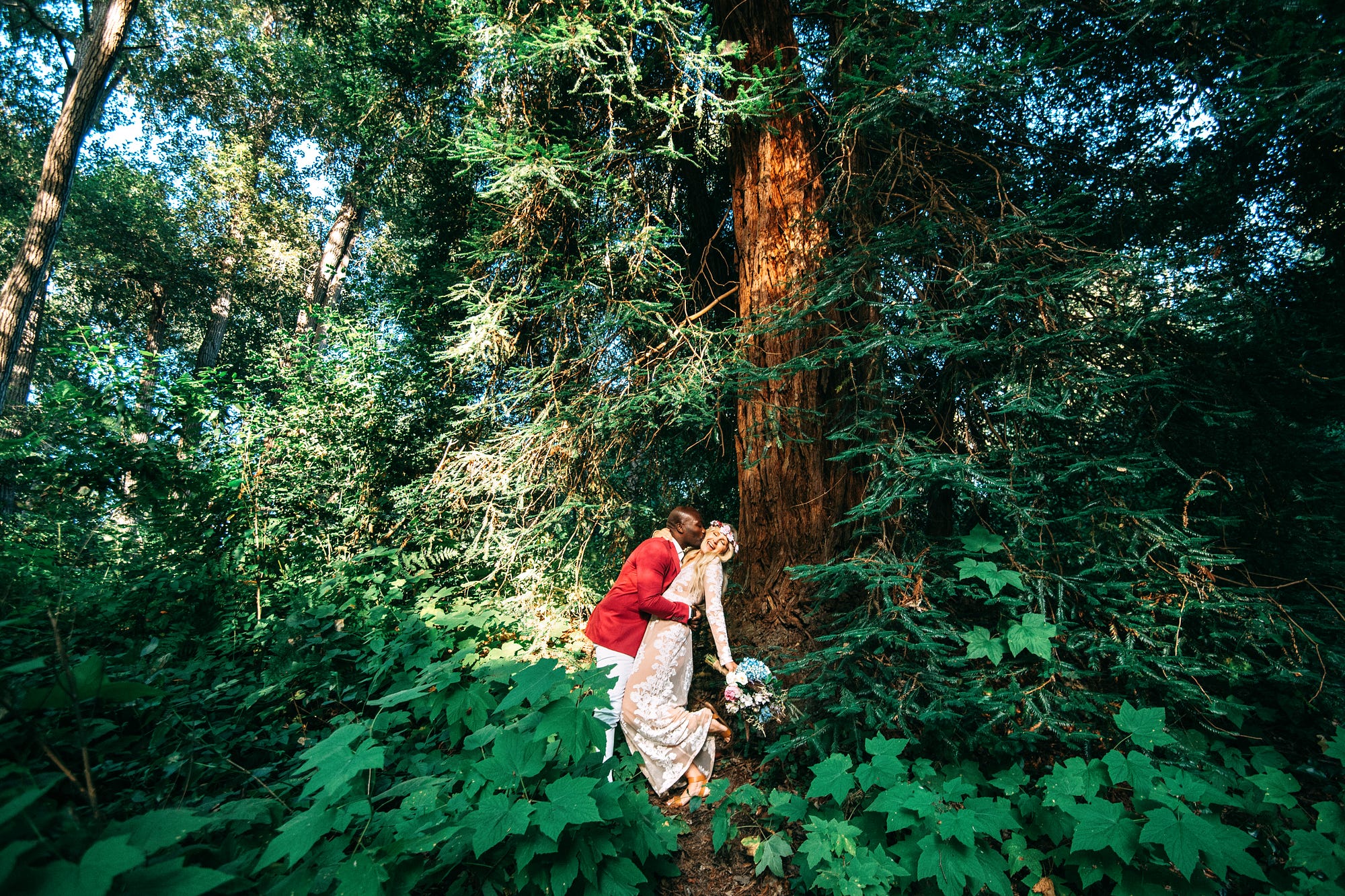 A couple kisses in the woods.