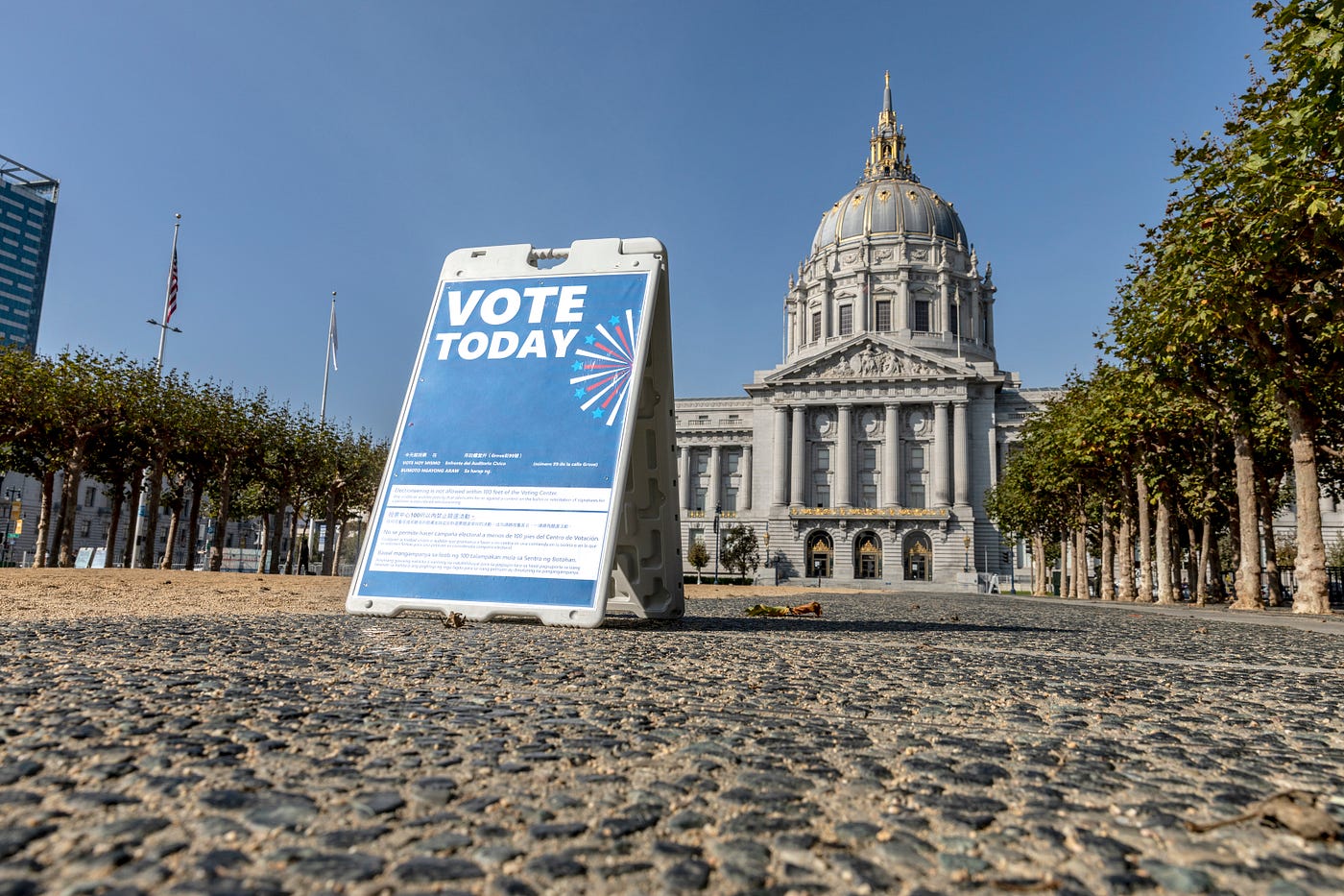 Low-angle shot of San Francisco City Hall, with a “vote today” sign in the foreground.