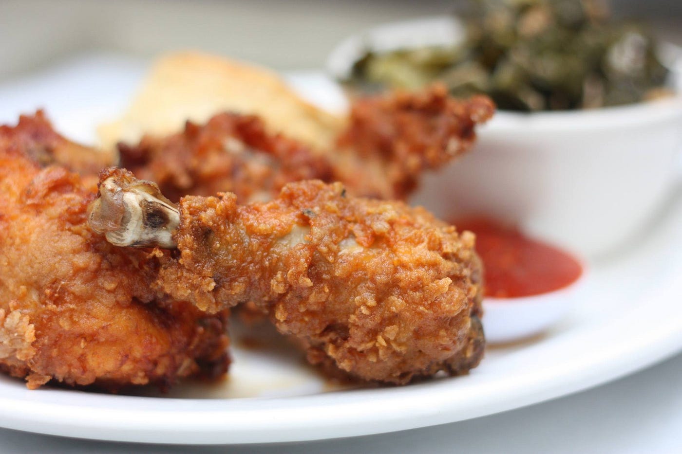 Fried chicken, and collard greens in a small bowl.
