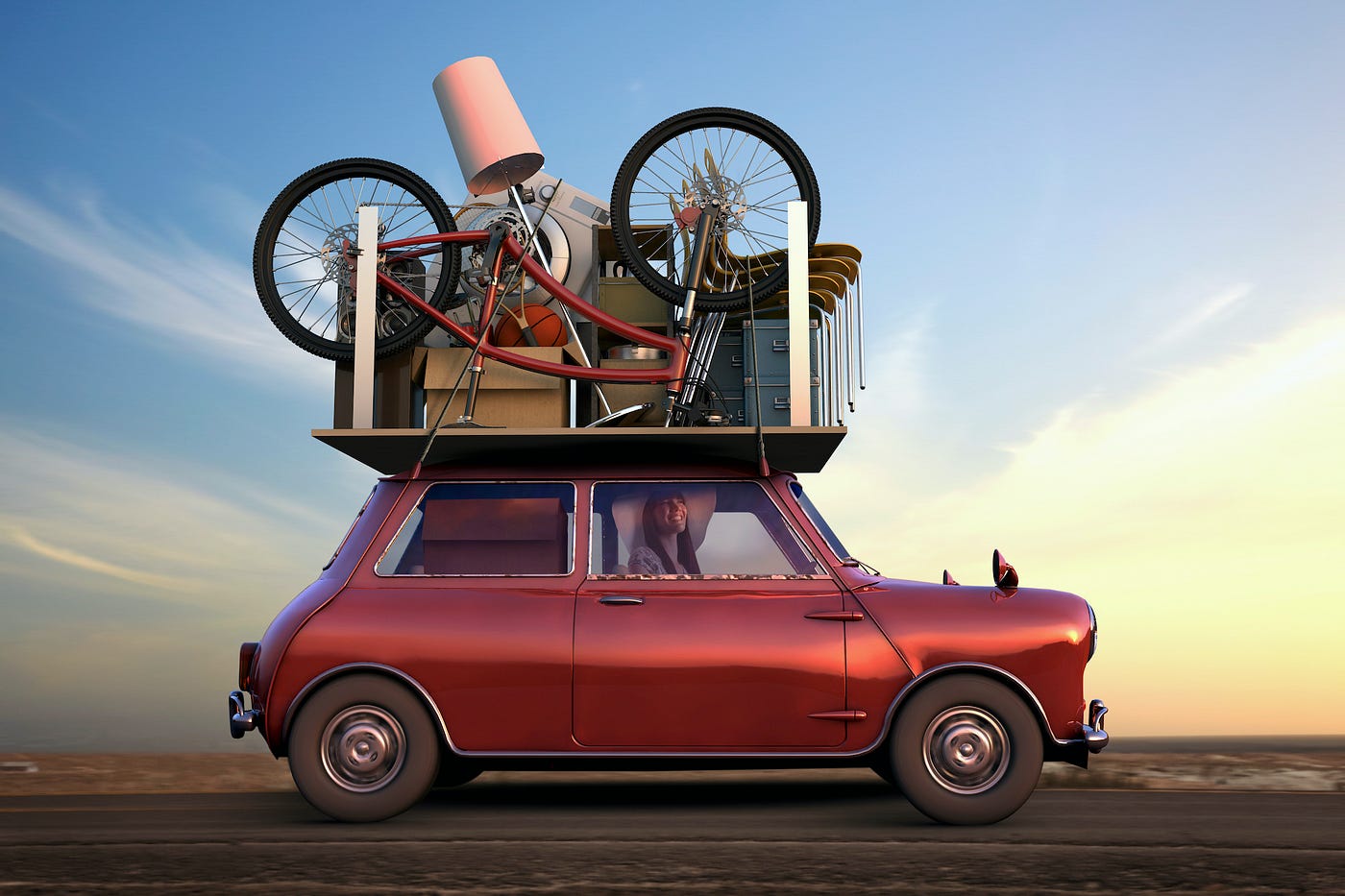 Vintage one-seater car with furniture piled high on its roof. It’s being driven through the desert at dusk by a smiling person wearing a floppy, wide-brimmed hat.