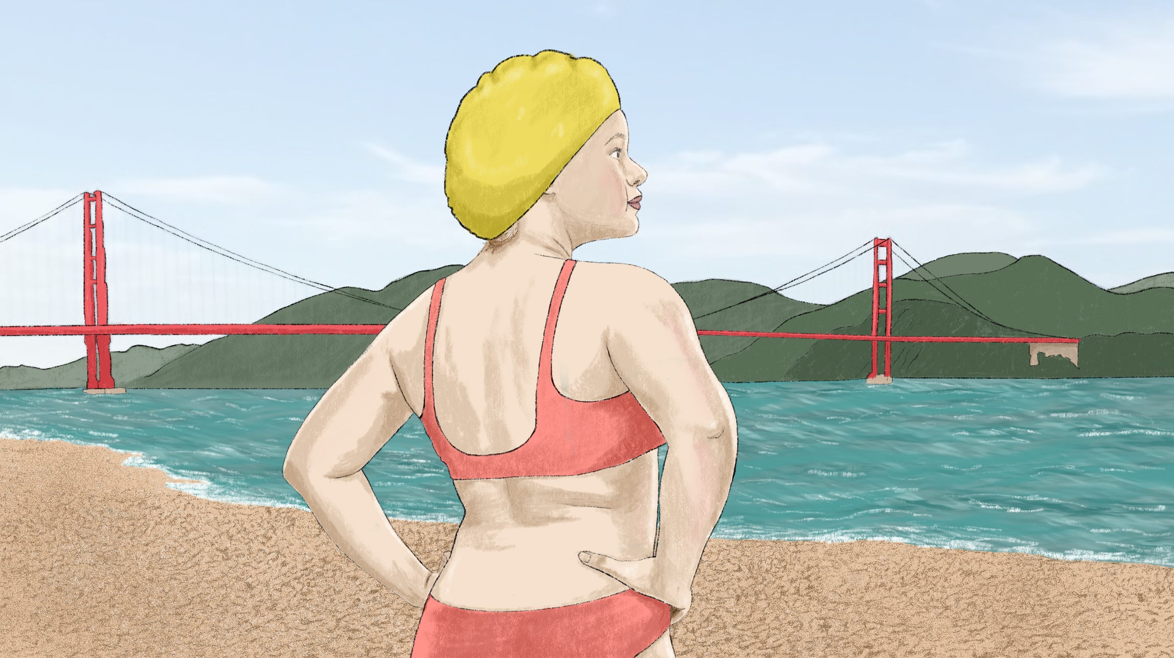 A person wearing a 2-piece bathing suit and a bathing cap standing by the Bay with the Golden Gate Bridge in the distance.