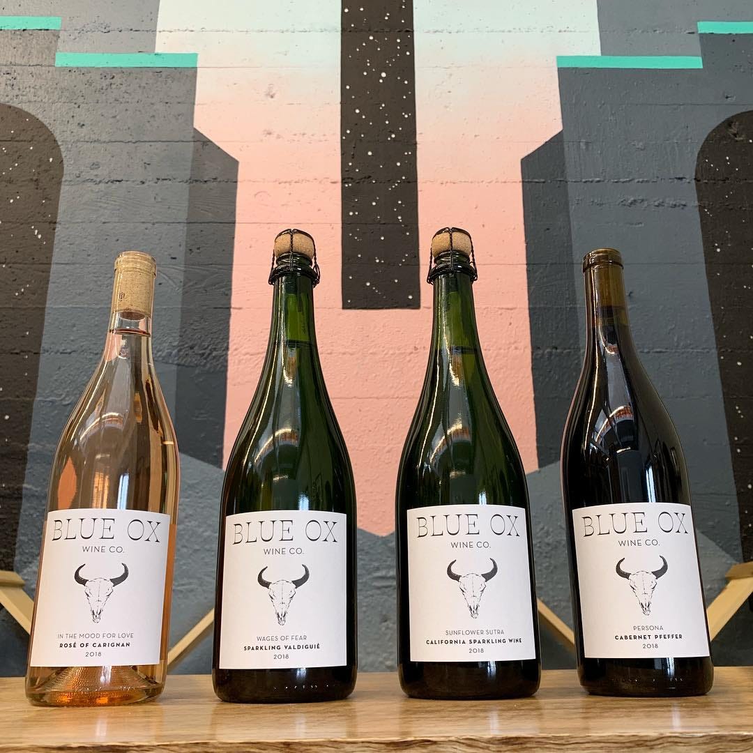 A bottle of Blue Ox rosé lined up next to 3 bottles of darker Blue Ox wines.