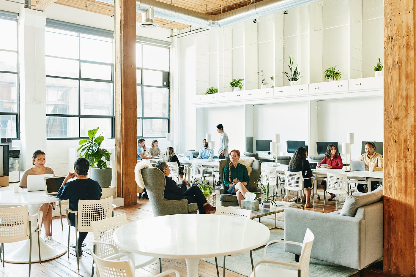 People working in a coworking space that’s airy and full of natural light thanks to large windows.