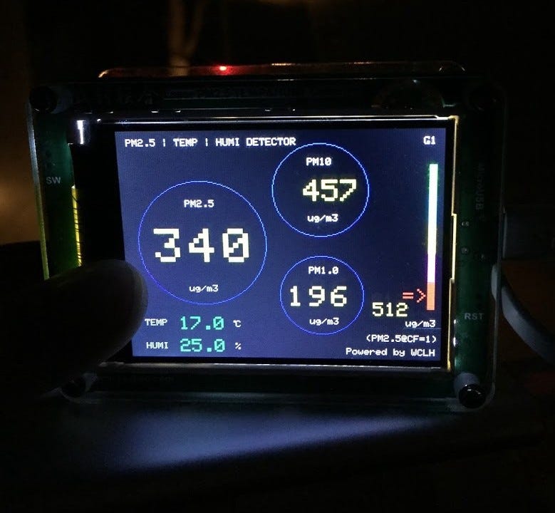 A digital air quality sensor display showing that the current PM2.5 is 340, the PM10 is 457, and the PM1.0 is 196.
